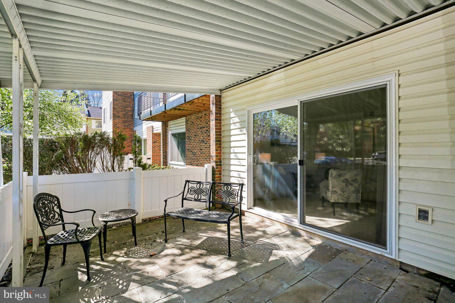 15020 Eardley Court, Unit 281G Silver Spring, MD 20906 - Photo 15 of 20 a view of a patio with table and chairs and floor to ceiling window