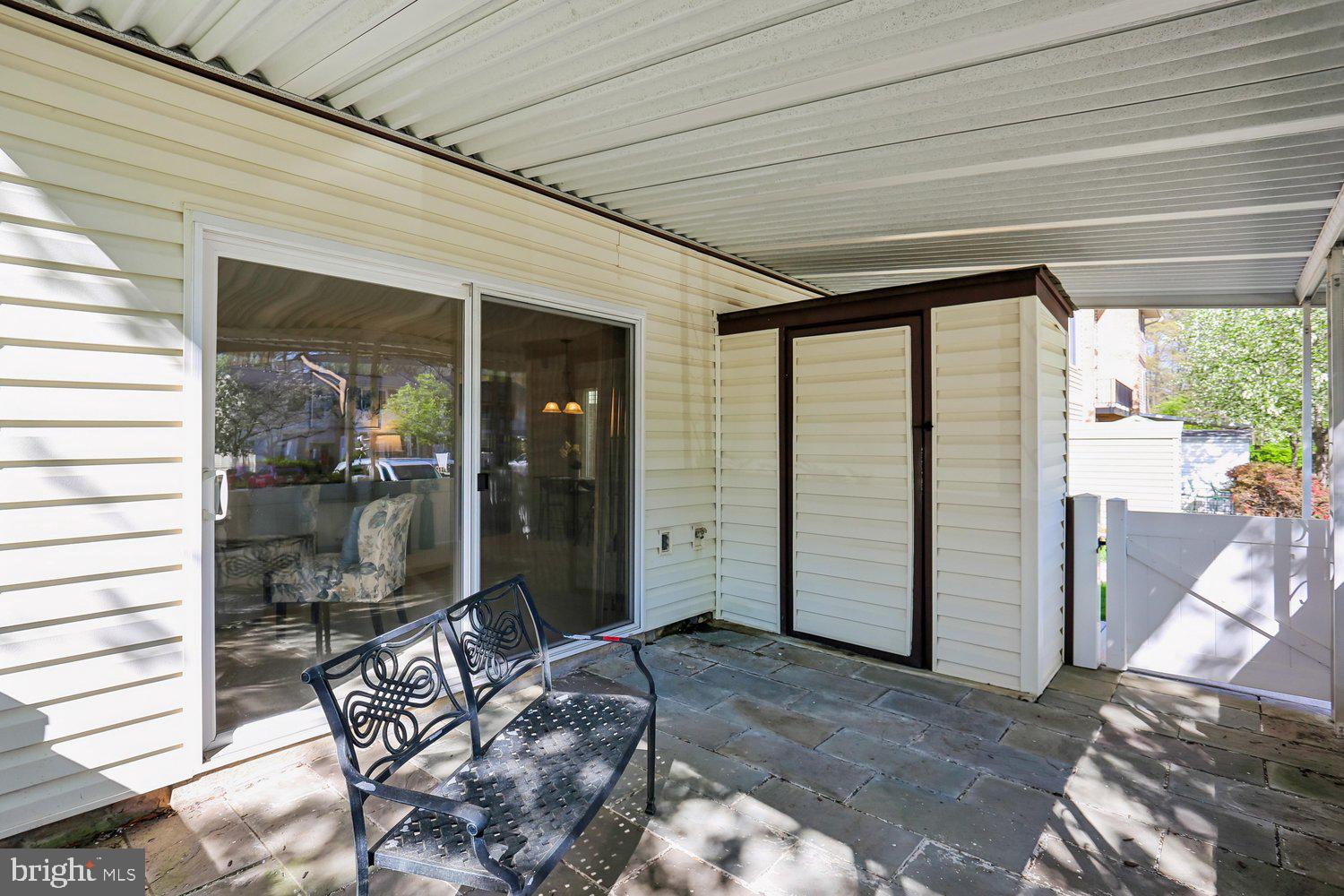 15020 Eardley Court, Unit 281G Silver Spring, MD 20906 - Photo 16 of 20 a porch with a table and chairs and potted plants