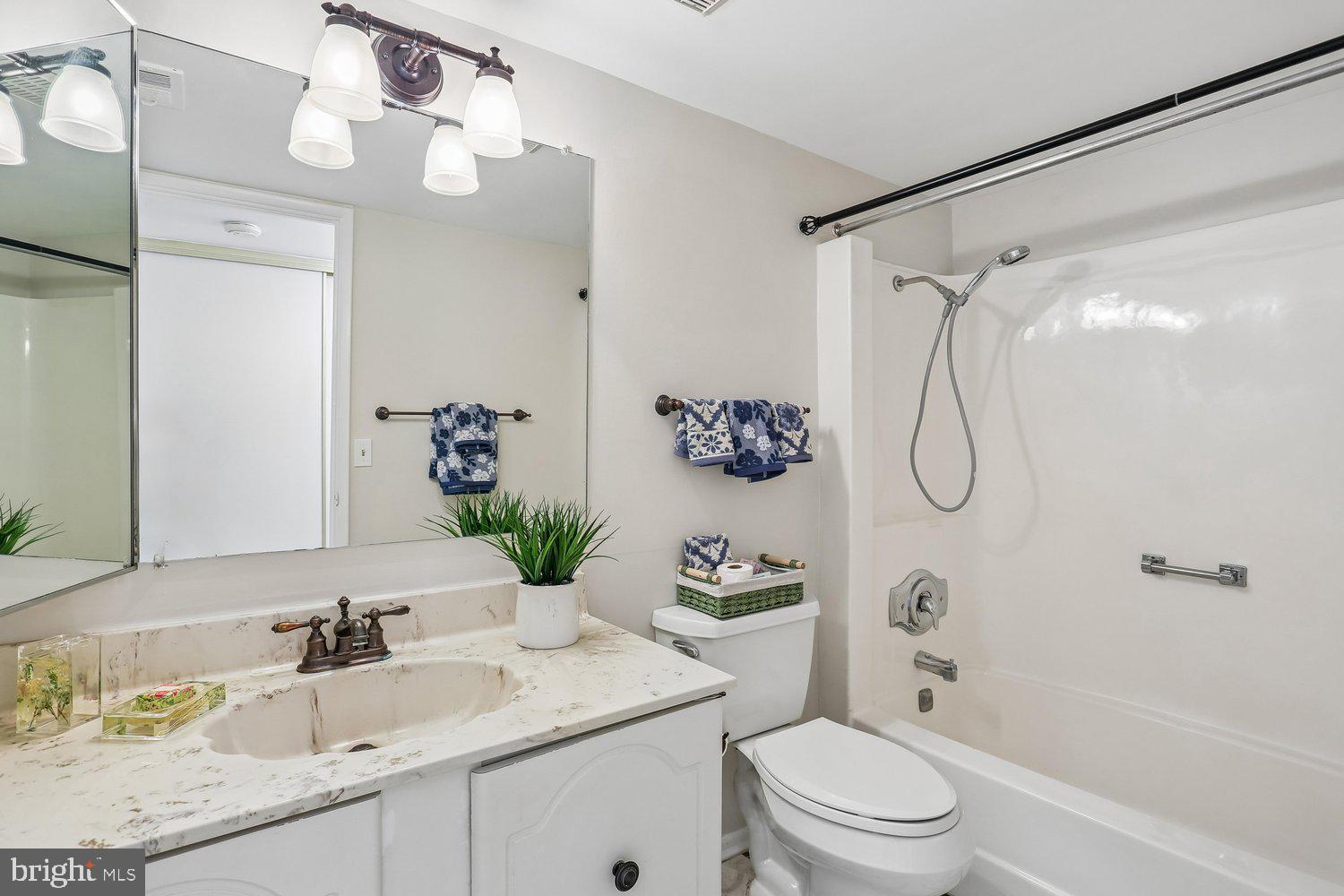 15020 Eardley Court, Unit 281G Silver Spring, MD 20906 - Photo 19 of 20 a bathroom with a granite countertop sink a toilet and shower