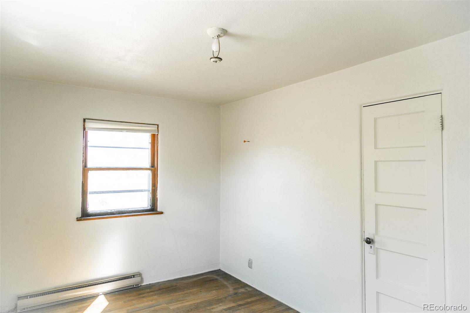 6771 West County Road Del Norte, CO 81132 - Photo 19 of 49 a view of an empty room with wooden floor and a window