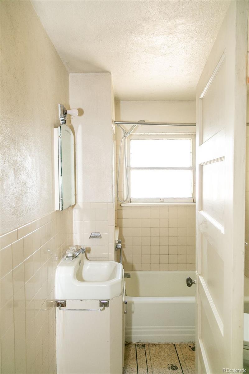 6771 West County Road Del Norte, CO 81132 - Photo 10 of 49 a bathroom with a sink mirror toilet and bathtub