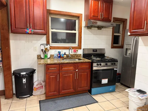 a kitchen with granite countertop a stove top oven microwave and cabinets