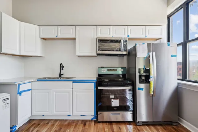a kitchen with stainless steel appliances granite countertop a refrigerator sink and stove