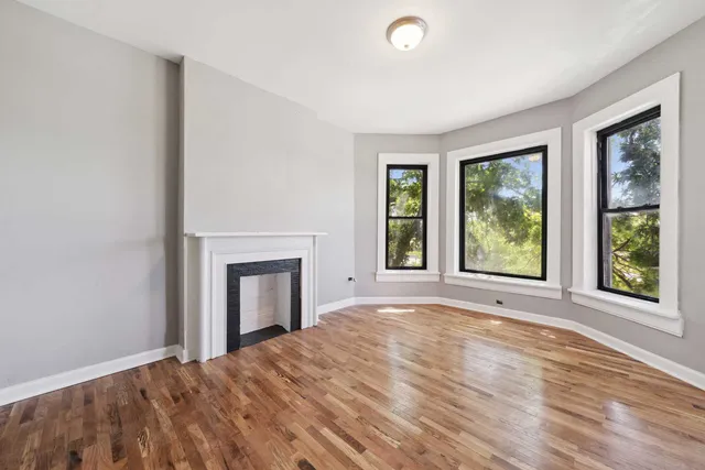 a view of an empty room with window and fire place