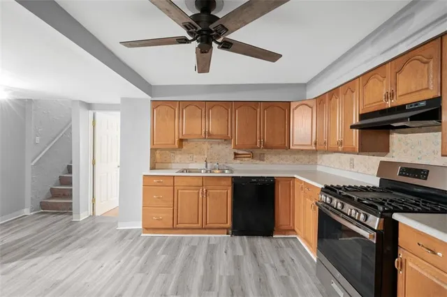 a kitchen with granite countertop a sink cabinets stainless steel appliances and a window