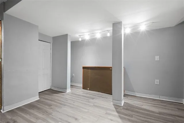 a view of empty room with wooden floor