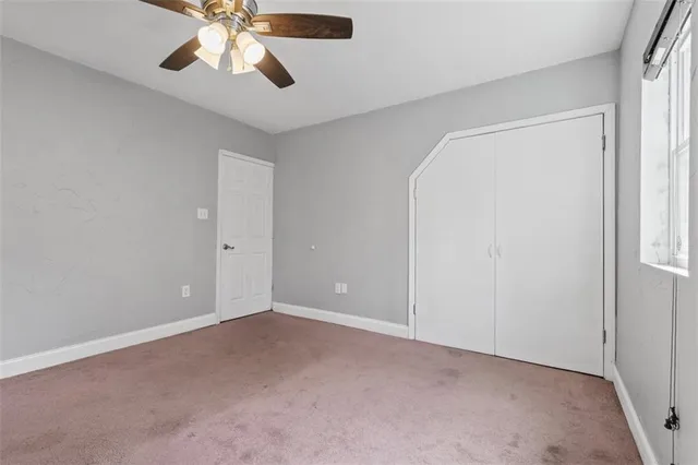 an empty room with chandelier fan