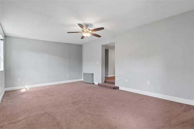 a view of an empty room with a ceiling fan