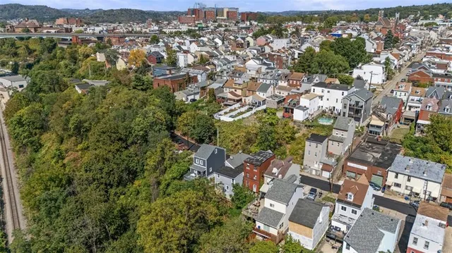 an aerial view of residential house with outdoor space and trees all around