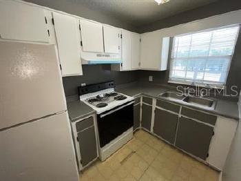 601 State Avenue, Unit 6 Daytona Beach, FL 32117 - Photo 3 of 7 a kitchen with granite countertop a sink a stove and refrigerator