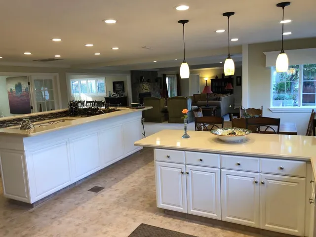 a living room with furniture kitchen view and a large window