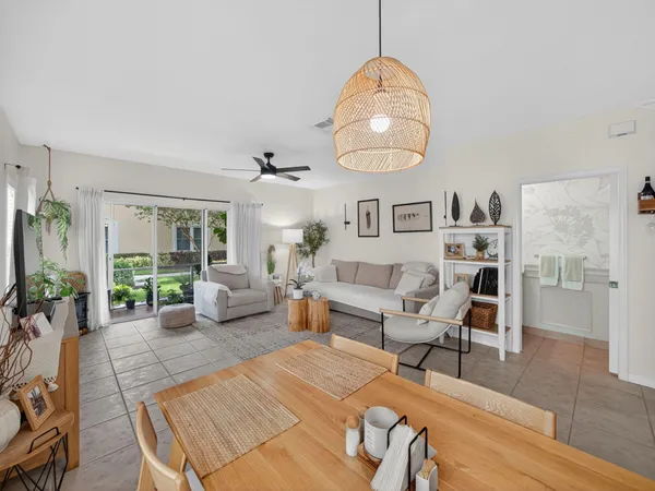 a living room with furniture a dining table and large windows
