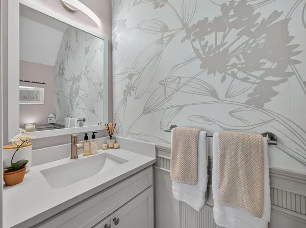 a bathroom with a sink and mirror with bathtub