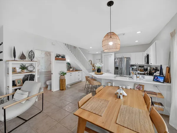 a large kitchen with stainless steel appliances granite countertop a stove a sink dishwasher and a dining table with the living room view