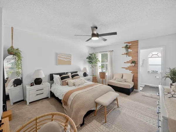 a bedroom with a bed couch and windows