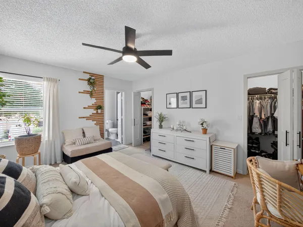 a bedroom with a bed and a large window