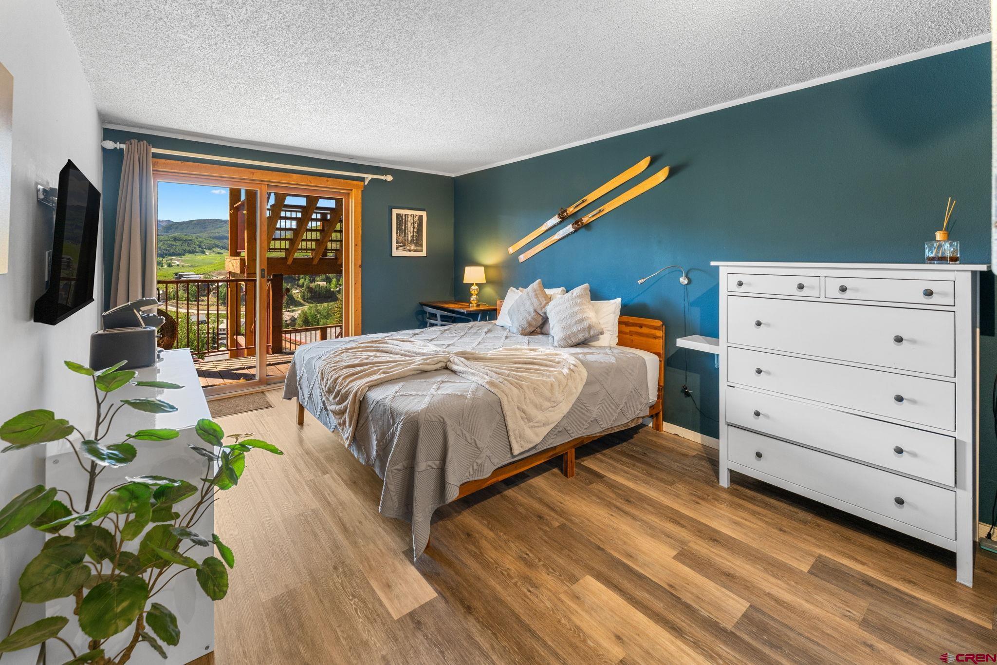 72 Hunter Hill Road, Unit I204 Crested Butte, CO 81225 - Photo 27 of 44 a bedroom with a bed table and a flat screen tv