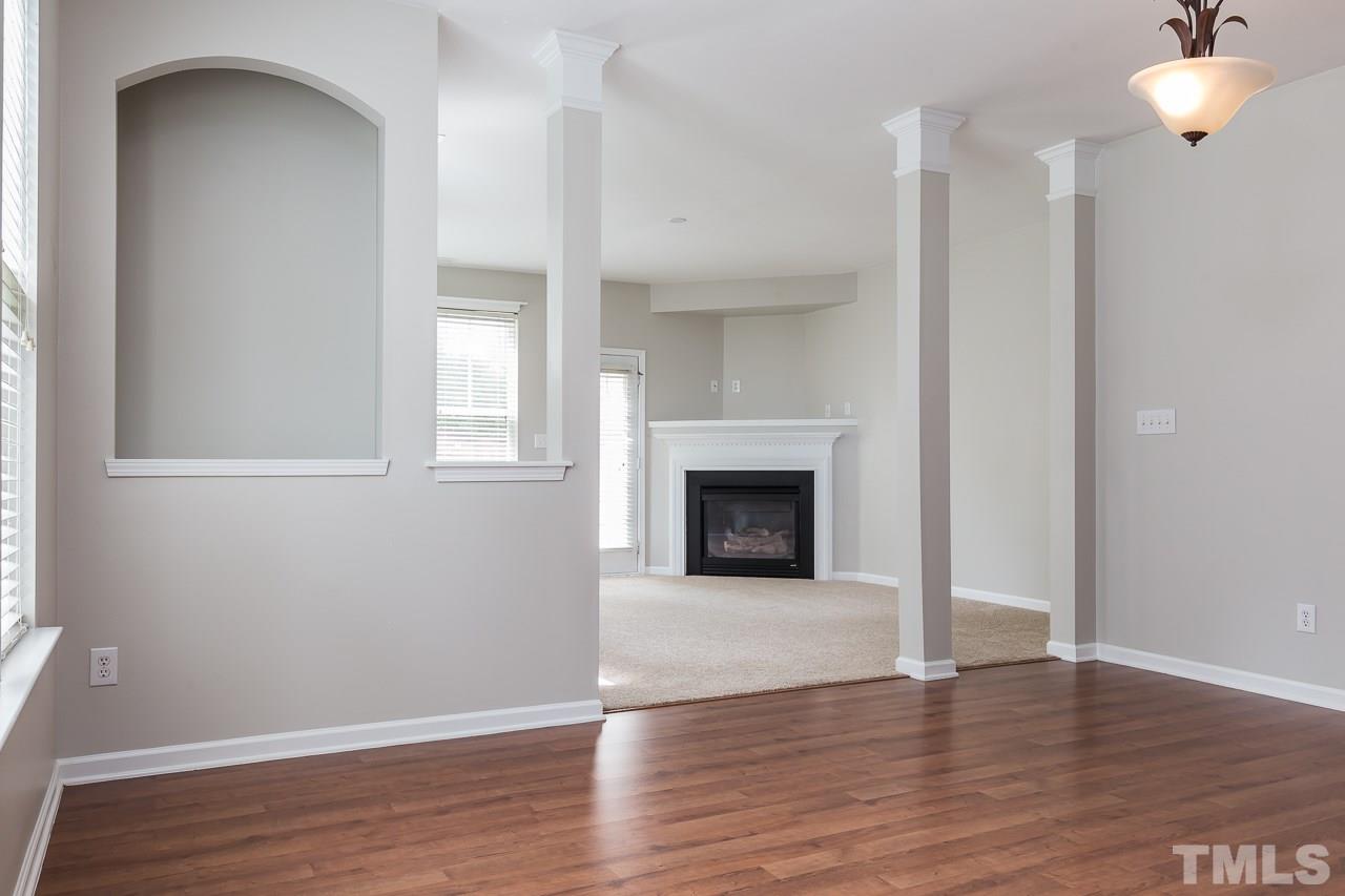 8485 Central Drive Raleigh, NC 27613 - Photo 3 of 25 a view of an empty room with wooden floor and a fireplace