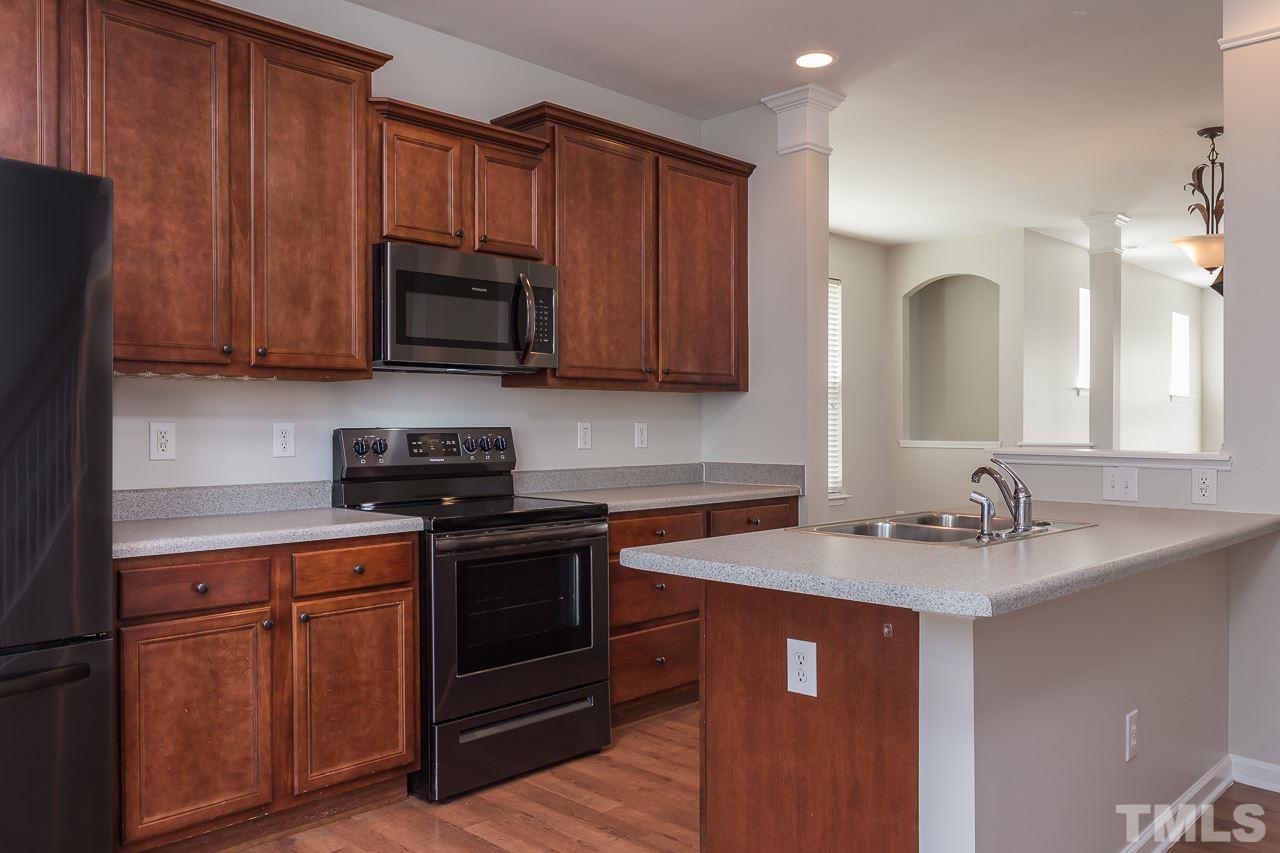 8485 Central Drive Raleigh, NC 27613 - Photo 7 of 25 a kitchen with stainless steel appliances granite countertop wooden cabinets a stove a sink and dishwasher