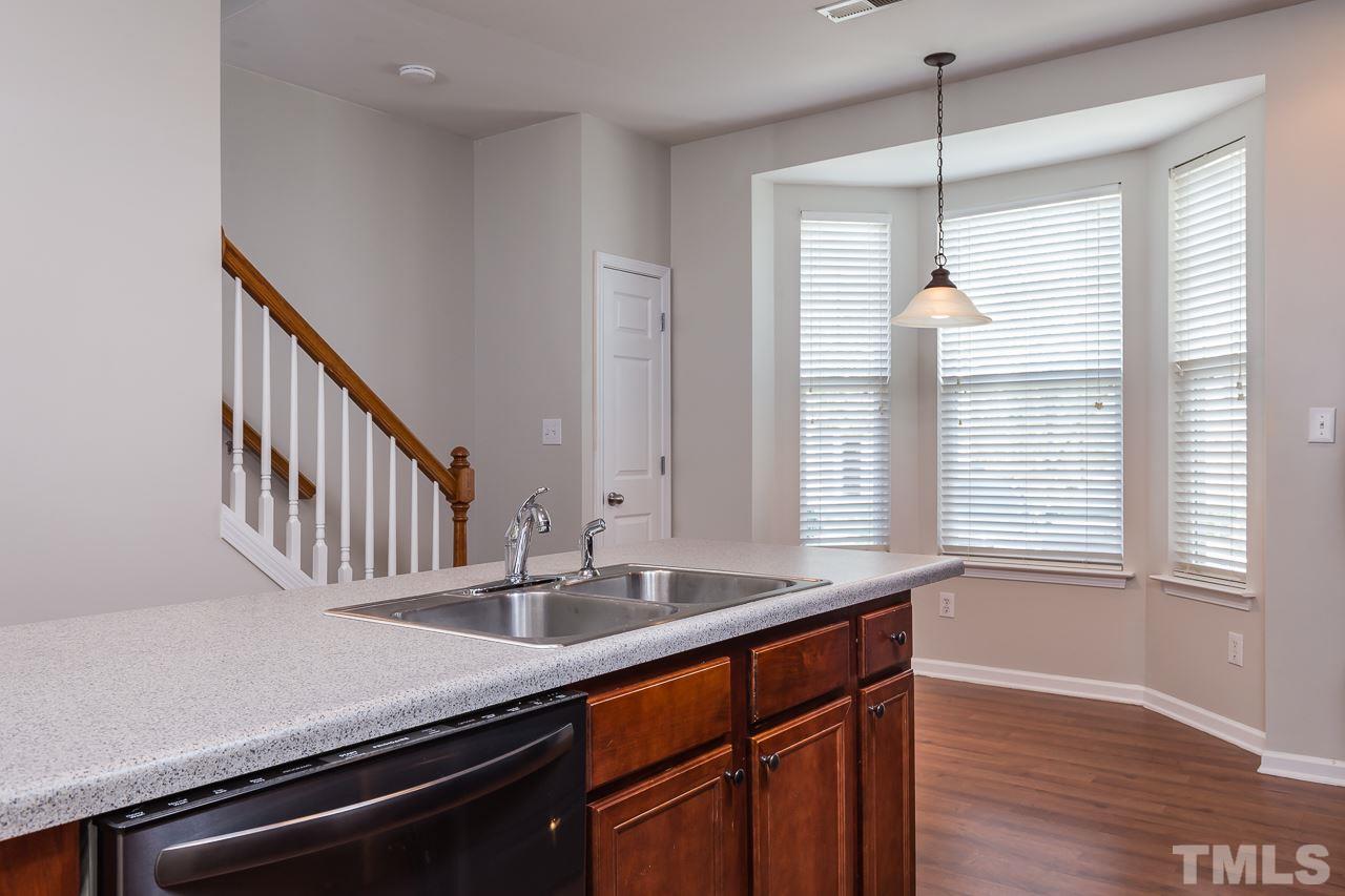 8485 Central Drive Raleigh, NC 27613 - Photo 8 of 25 a kitchen with granite countertop a sink cabinets and wooden floor