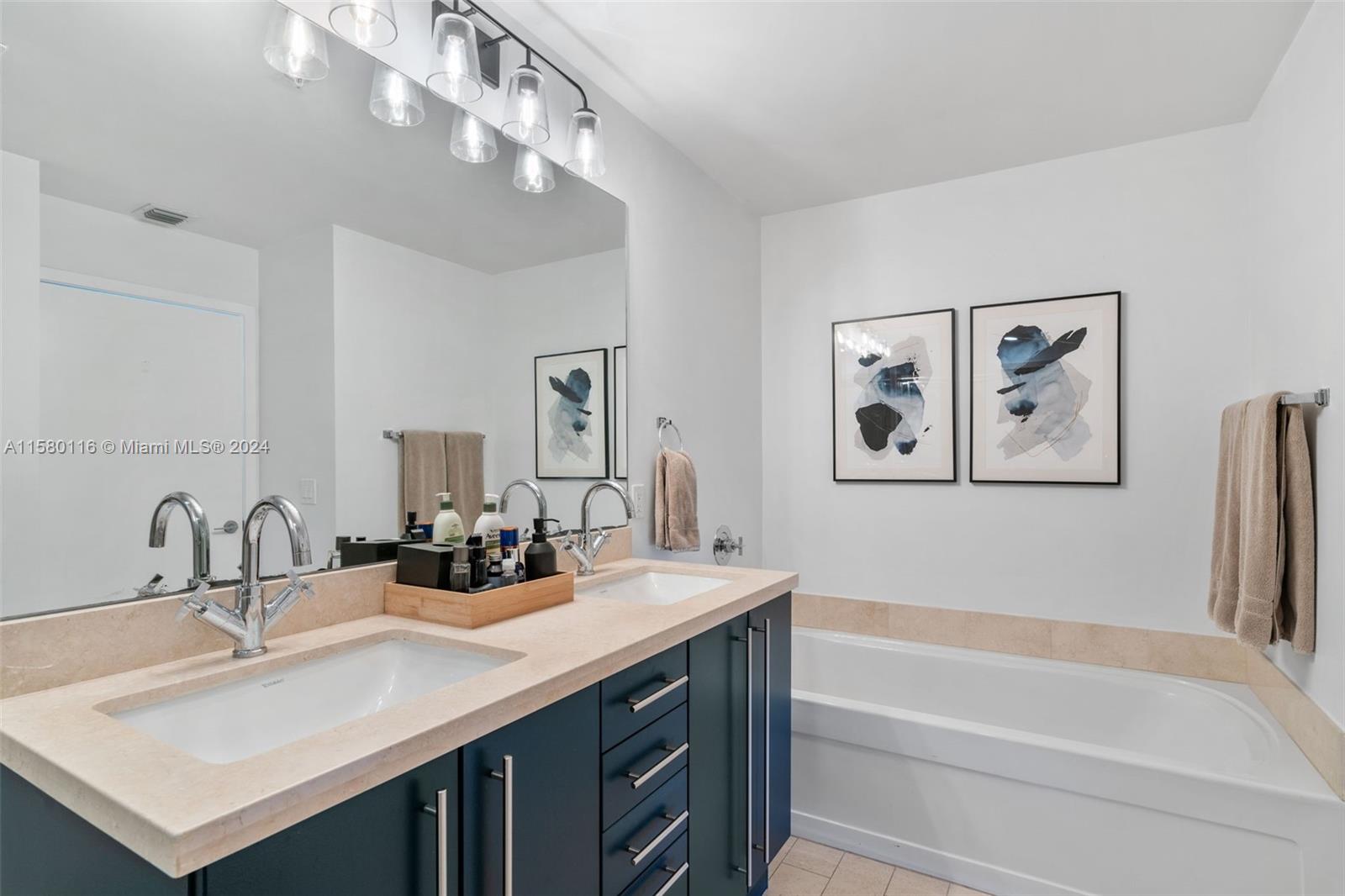 79 Southwest 12th Street, Unit 2204S Miami, FL 33130 - Photo 16 of 40 a bathroom with a sink a large mirror and a bathtub