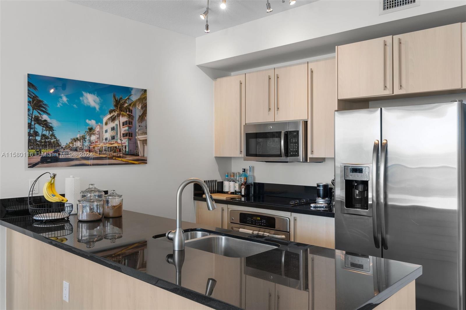 79 Southwest 12th Street, Unit 2204S Miami, FL 33130 - Photo 4 of 40 a kitchen with stainless steel appliances granite countertop a sink a stove and a refrigerator