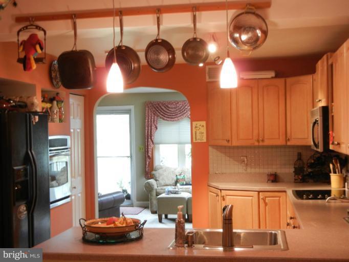 4040 Cliffvale Road Baltimore, MD 21236 - Photo 12 of 25 a kitchen with a stove a refrigerator and a dining table