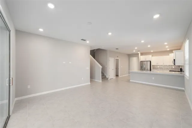 a view of an empty room and kitchen view