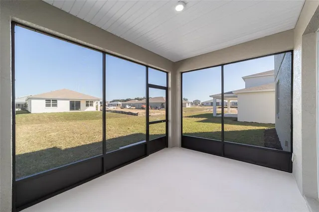 a view of an empty room with large windows
