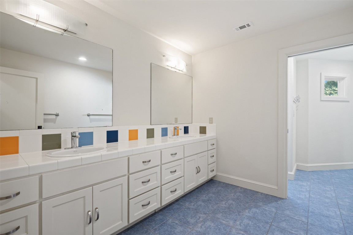 7603 Rustling Cove Austin, TX 78731 - Photo 24 of 34 a bathroom with a double vanity sink and mirror