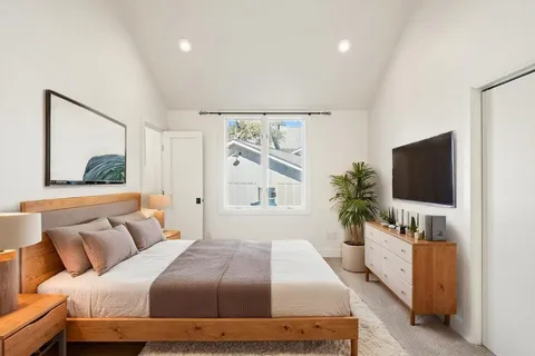 a bedroom with a large bed and a flat screen tv