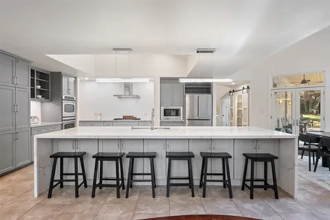 a large white kitchen with a table and chairs
