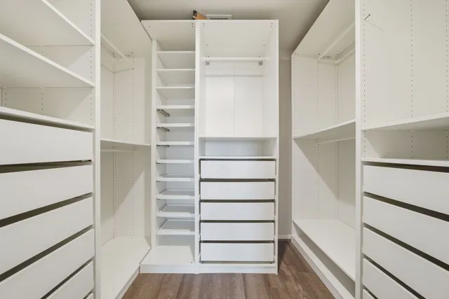 a view of walk in closet with empty racks