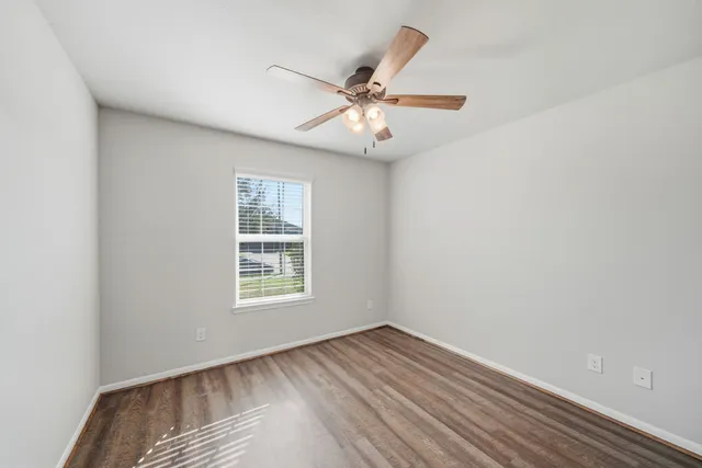 a view of empty room with wooden floor