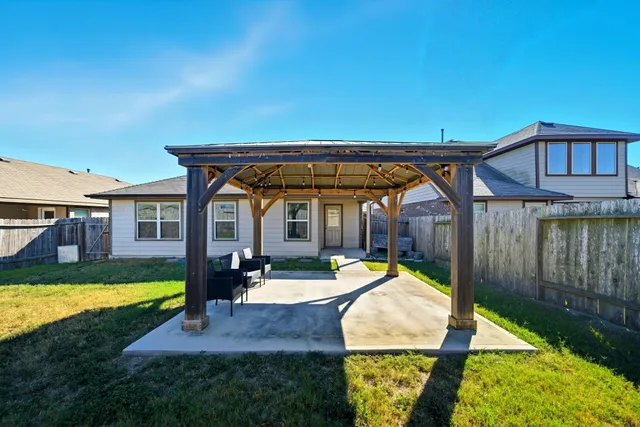 a view of a backyard with table and chairs