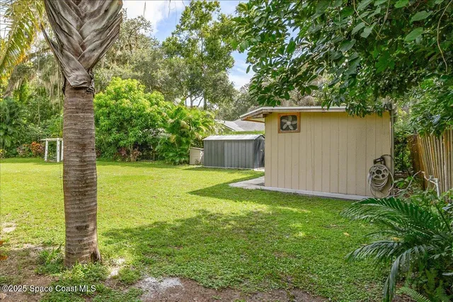 a view of an empty room with kitchen and a window