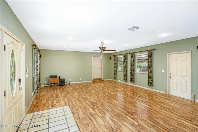 a view of empty room with wooden floor