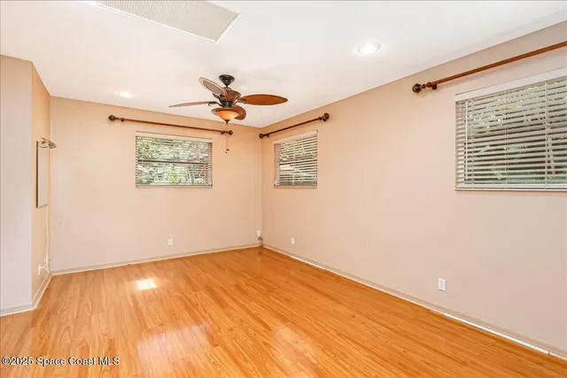 a view of a livingroom with wooden floor and a bathroom