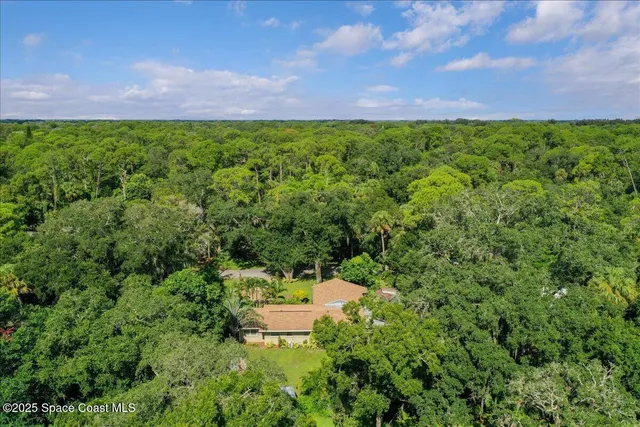 a yellow house with flower garden in front of it
