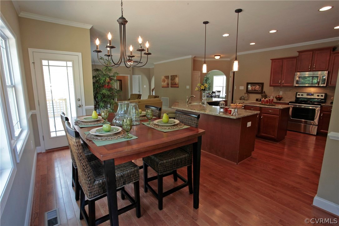 11024 Avening Road Midlothian, VA 23112 - Photo 4 of 16 a view of a dining room and livingroom with furniture wooden floor a chandelier