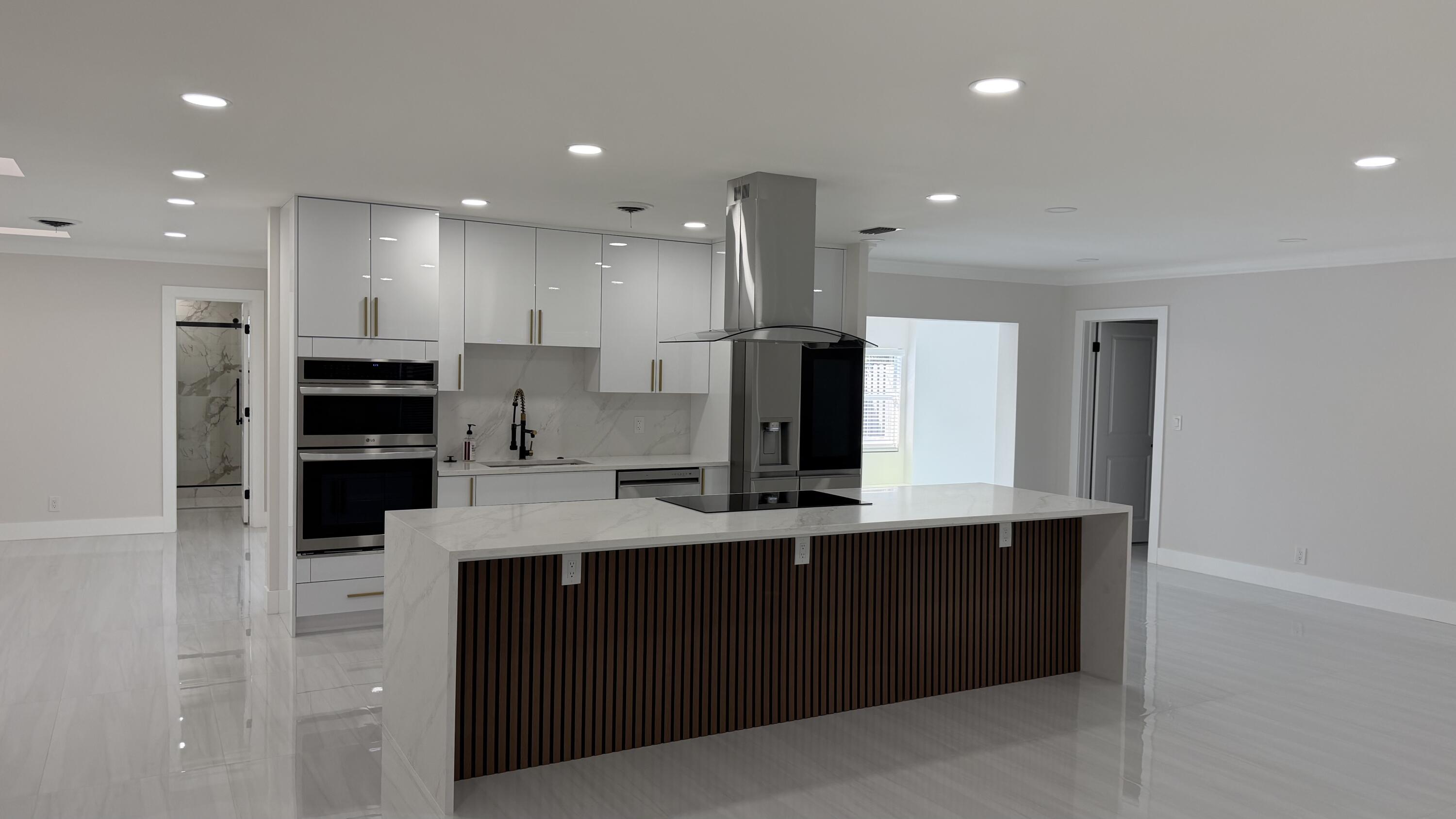 2521 Northeast 45th Street Lighthouse Point, FL 33064 - Photo 5 of 25 a kitchen with kitchen island a sink stainless steel appliances and cabinets