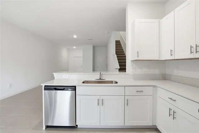 a kitchen with white cabinets and white appliances