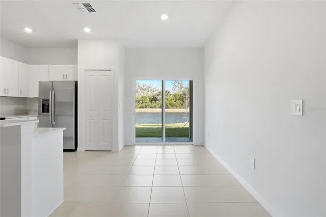 a view of a kitchen with refrigerator and white cabinets