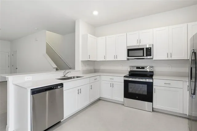 a kitchen with stainless steel appliances granite countertop a sink and a microwave