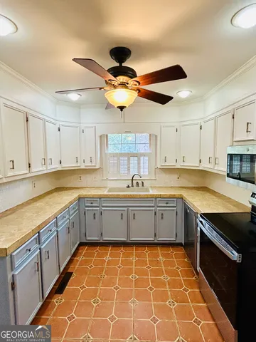 a kitchen with stainless steel appliances a stove a sink and cabinets