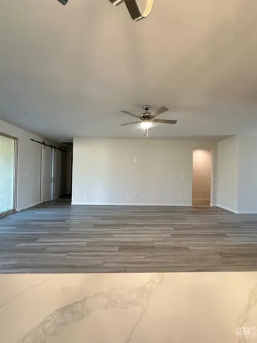 a view of a livingroom with a ceiling fan and wooden floor