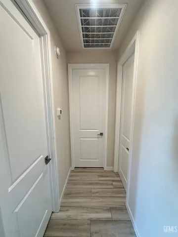 a view of a hallway with wooden floor and closet