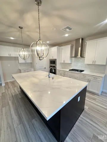 a large kitchen with stainless steel appliances a large center island attached withe living room