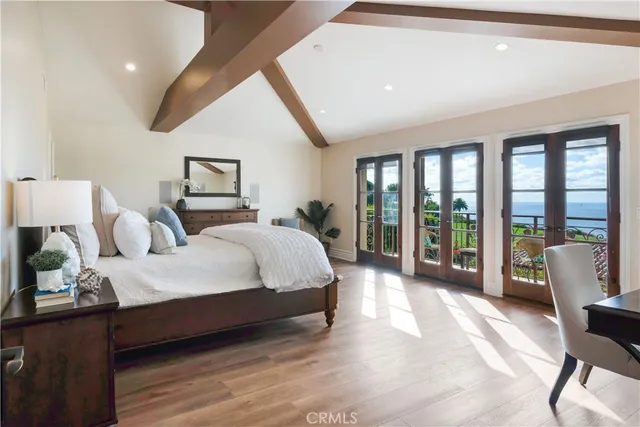 a spacious bedroom with a bed and wooden floor