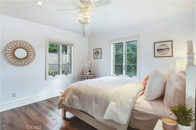 a spacious bedroom with a bed and wooden floor
